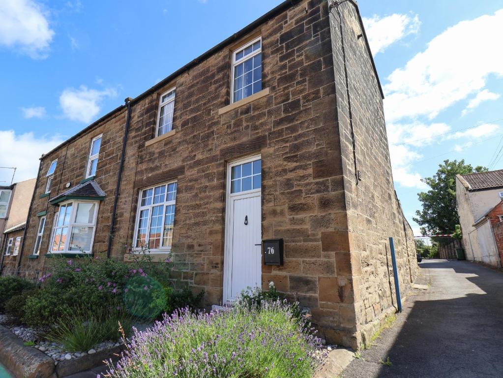 an old brick building with a white door at 76 High Street in Redcar