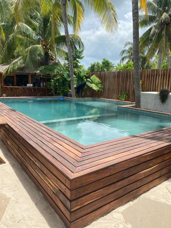 a swimming pool with a wooden deck around it at Ah Muzenkab in El Cuyo