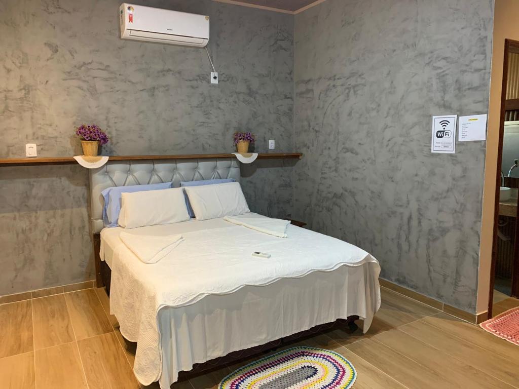 1 dormitorio con 1 cama con manta blanca en POUSADA IRMAOS ATINS, en Atins