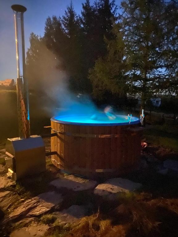 a person throwing a blue frisbee into a barrel at Domek Ostoja Góry Sowie in Łomnica