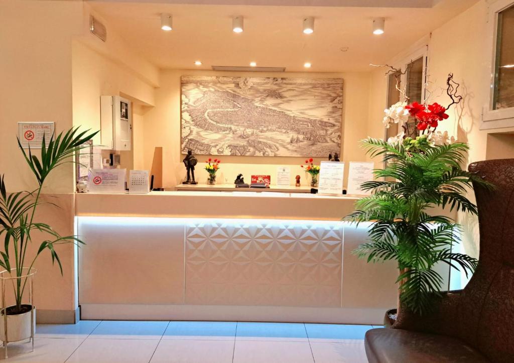 a lobby with a counter with a large painting on the wall at Hotel Laguna Residence in Marghera