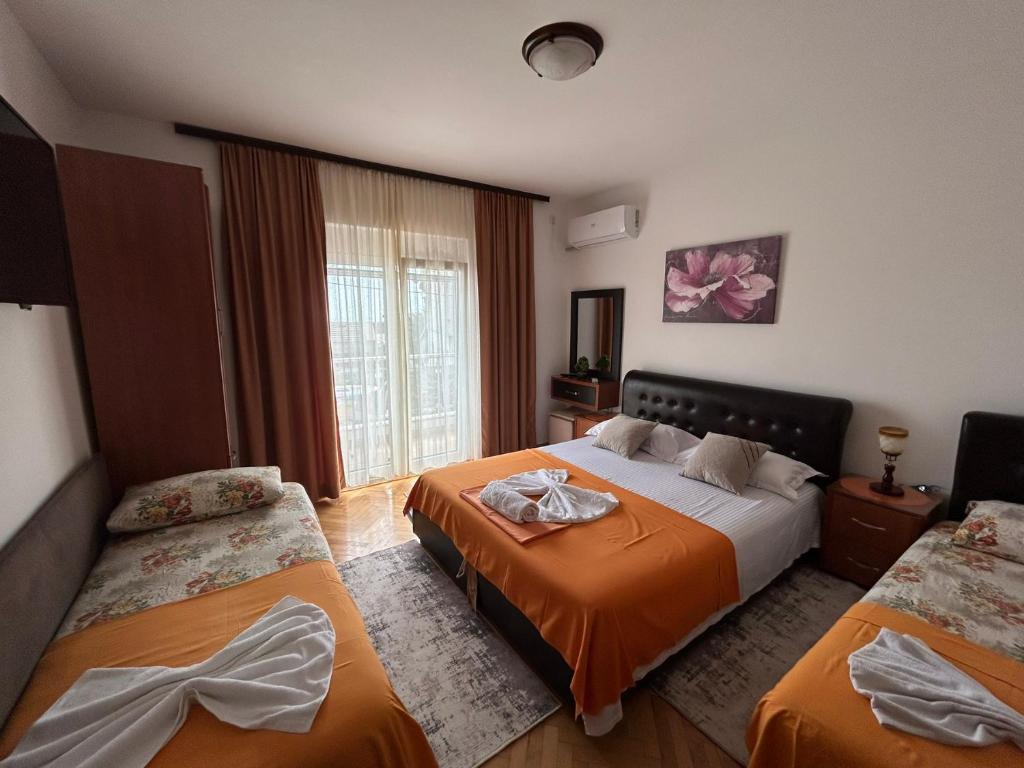 ウルツィニにあるApartments Gaziのベッド2台と窓が備わるホテルルームです。