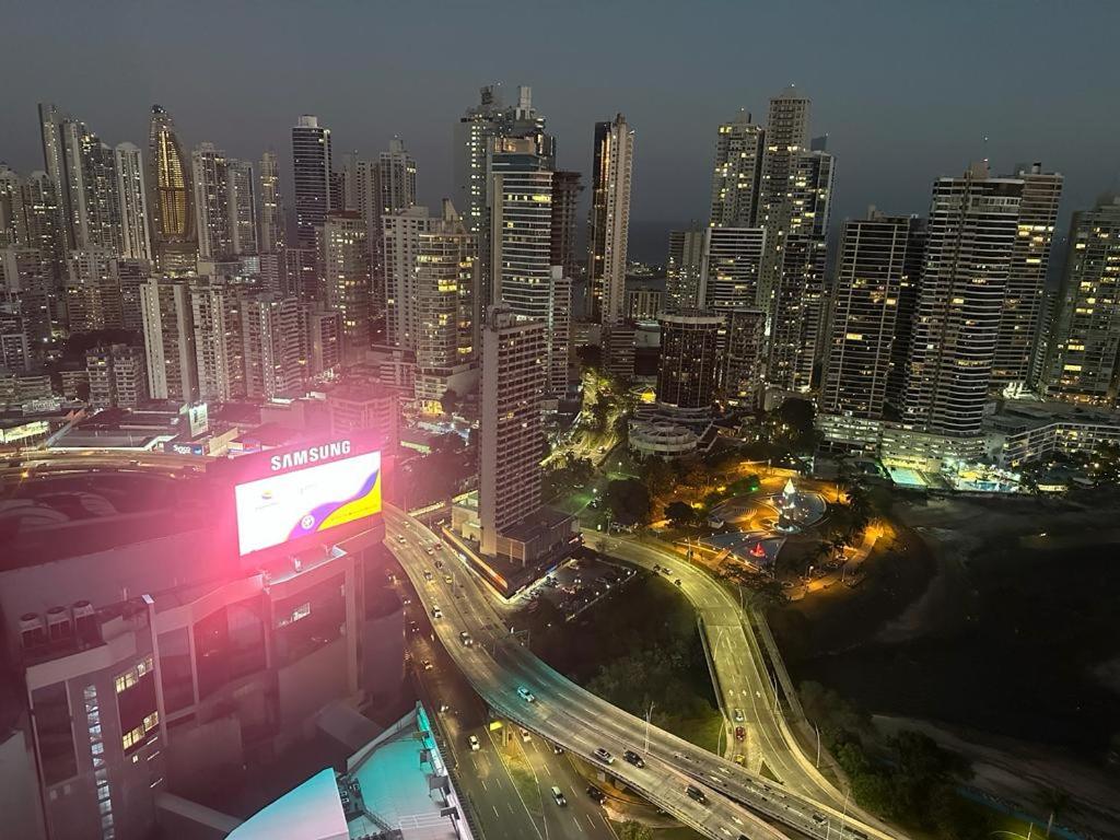 een skyline van de stad 's nachts met verkeer op een snelweg bij Grand Bay Tower in Panama-Stad