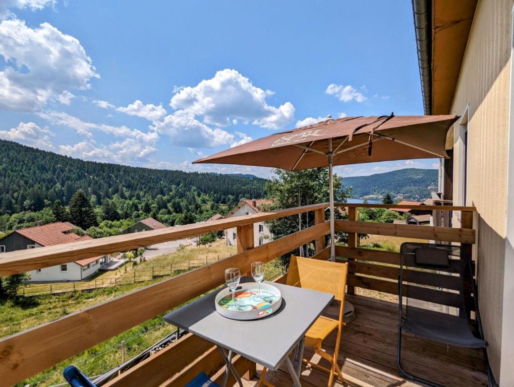 - une table sur un balcon avec un parasol dans l'établissement Le Pic Noir, à Gérardmer