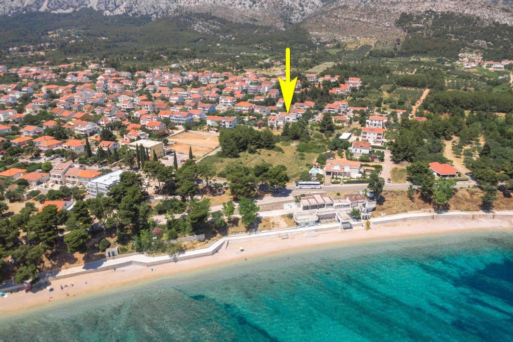 an aerial view of a beach with a yellow arrow at apartmani stefan in Orebić