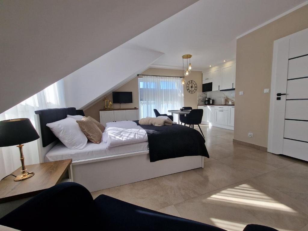 a bedroom with a bed and a living room at Apartamenty Malaga II in Darłowo