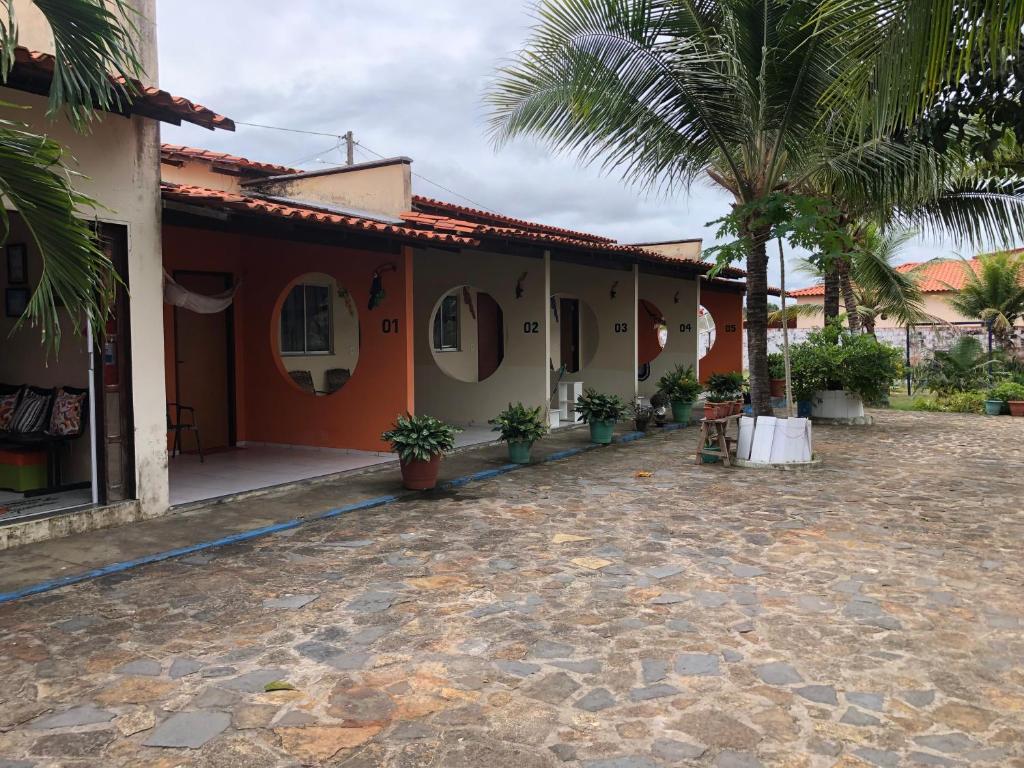 una casa con un patio con una palmera en Pousada Chácara do Coqueiro, en Barreirinhas