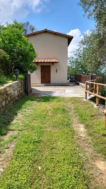 ein weißes Haus mit einem Tor und einem Hof in der Unterkunft Casa VALGRAZIOSA in Calci