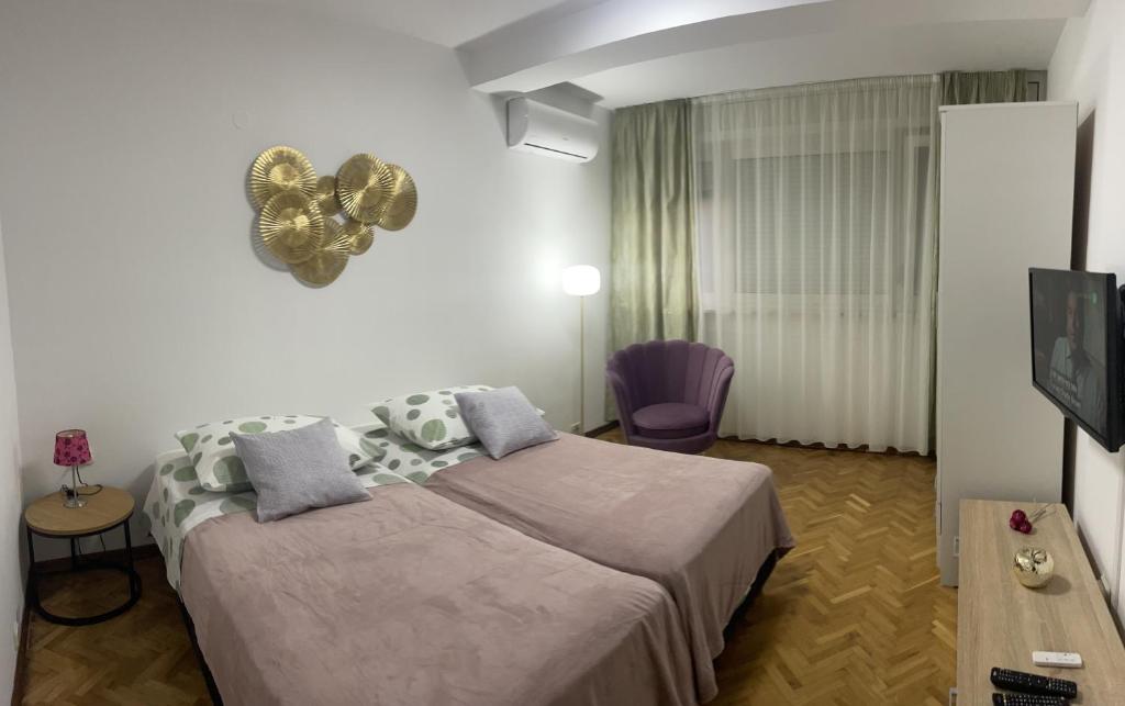 a bedroom with a large bed and a tv at Apartman Doris in Split