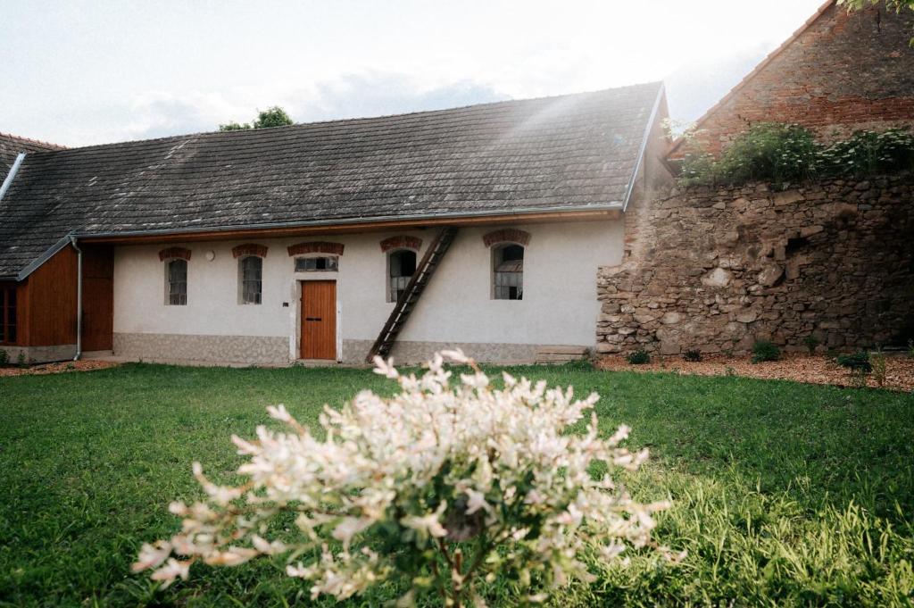 Casa blanca con techo marrón y pared de piedra en Usedlost Jindřichovice, 