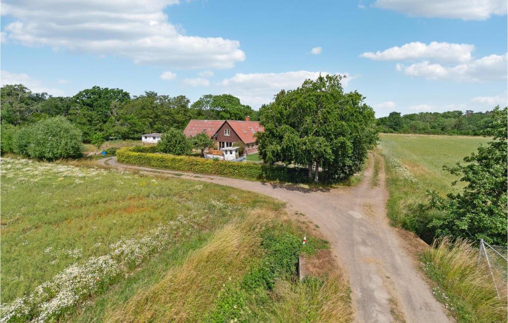 a dirt road leading to a house in a field at 2 Bedroom Nice Apartment In Aakirkeby in Åkirkeby