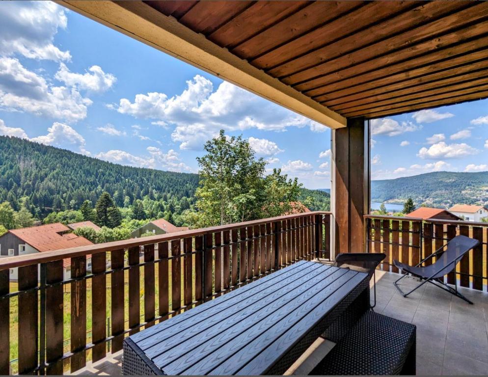 a wooden deck with a bench on a balcony at Appartement Le Grand Duc in Gérardmer