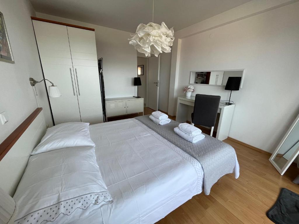 a bedroom with a large white bed and a desk at La Fee studio apartment in Hvar
