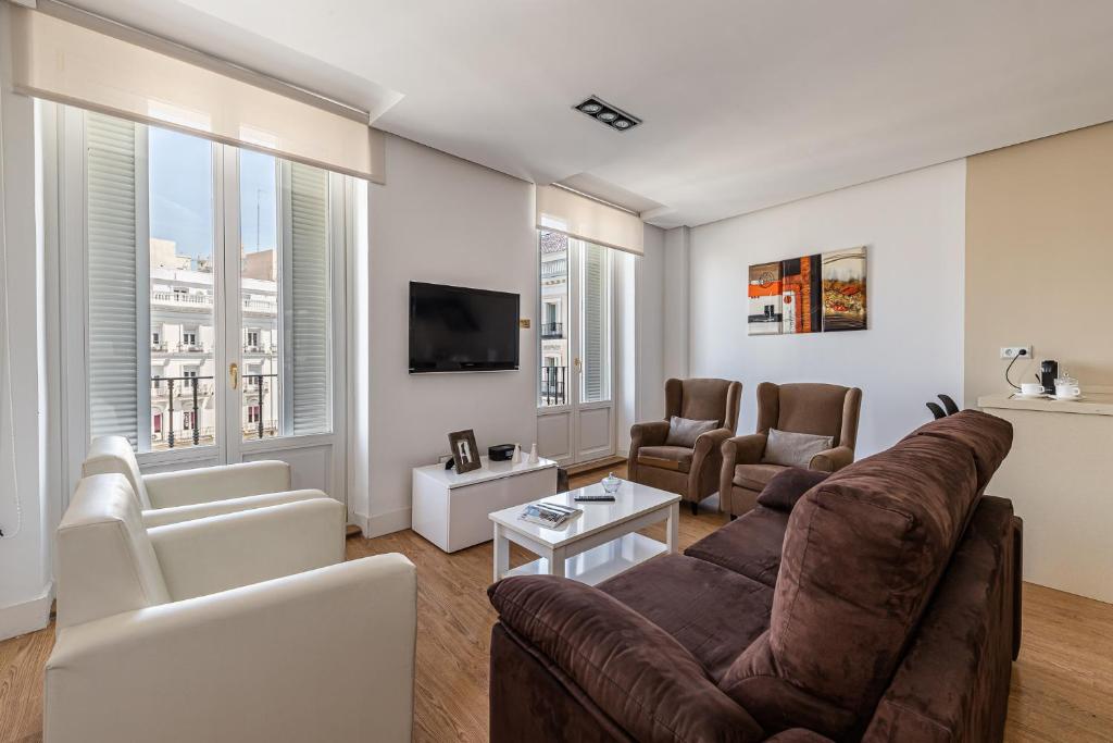 uma sala de estar com um sofá e uma televisão em BNBHolder Apartamentos en Sol Deluxe 1 em Madrid