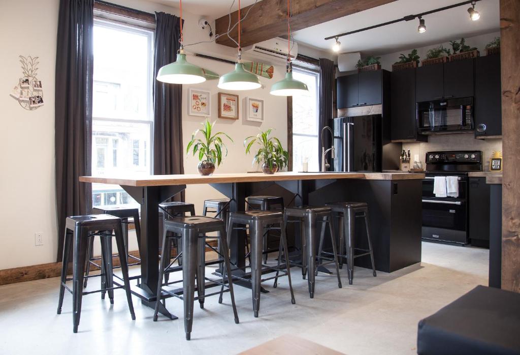 a kitchen with a large wooden island with bar stools at Le Bed & Cocktail - Appartement sur l'Avenue du Mont-Royal in Montréal