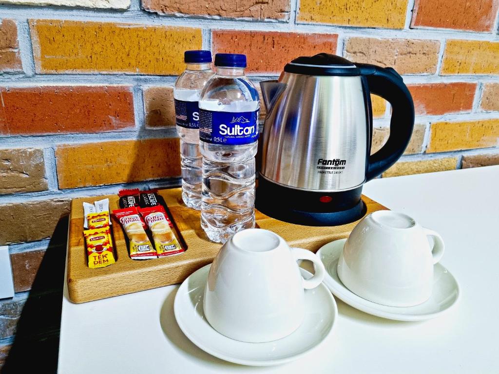 Paradise İmroz Butik Otel في غوكجيادا: كاونتر مع وعاء القهوة وزجاجات المياه