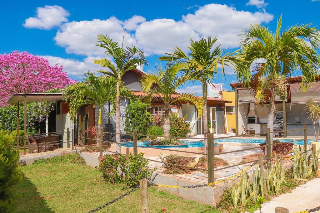 a house with a swimming pool and palm trees at Portal Da Mata in Santa Fé do Sul