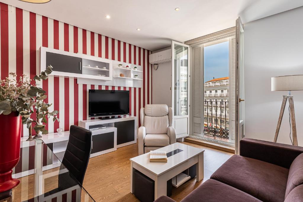 a living room with a red and white striped wall at BNBHolder Apartamentos en Sol Superior 2 in Madrid