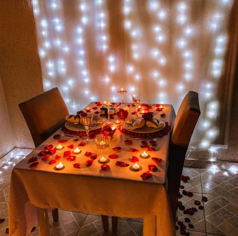 a table with candles and red flowers on it at Departamento para parejas in Guayaquil