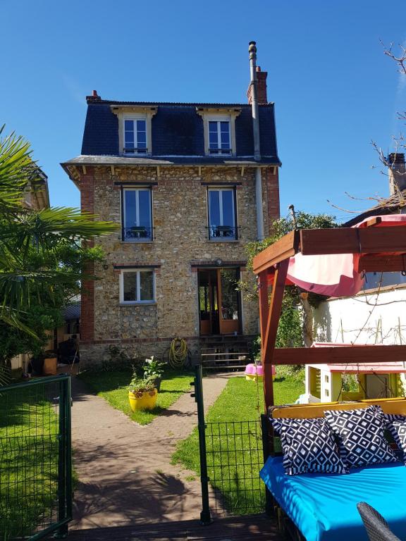 une grande maison en briques avec un toit dans l'établissement 2 Chambres d 'hôtes chez un particulier avec piscine, à Saint-Leu-la-Forêt