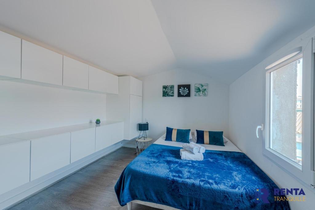 Un dormitorio con una cama azul y una ventana en L'Etang WIFI Near the sea en Leucate