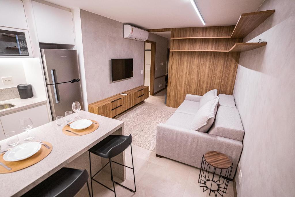 una pequeña sala de estar con sofá y mesa. en Apartamento novo de alto padrão e aconchegante#223 en Brasilia
