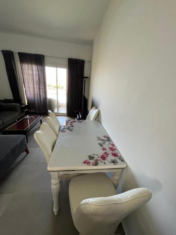 a white table and chairs in a living room at amwaj in Dawwār Ruḩayyim