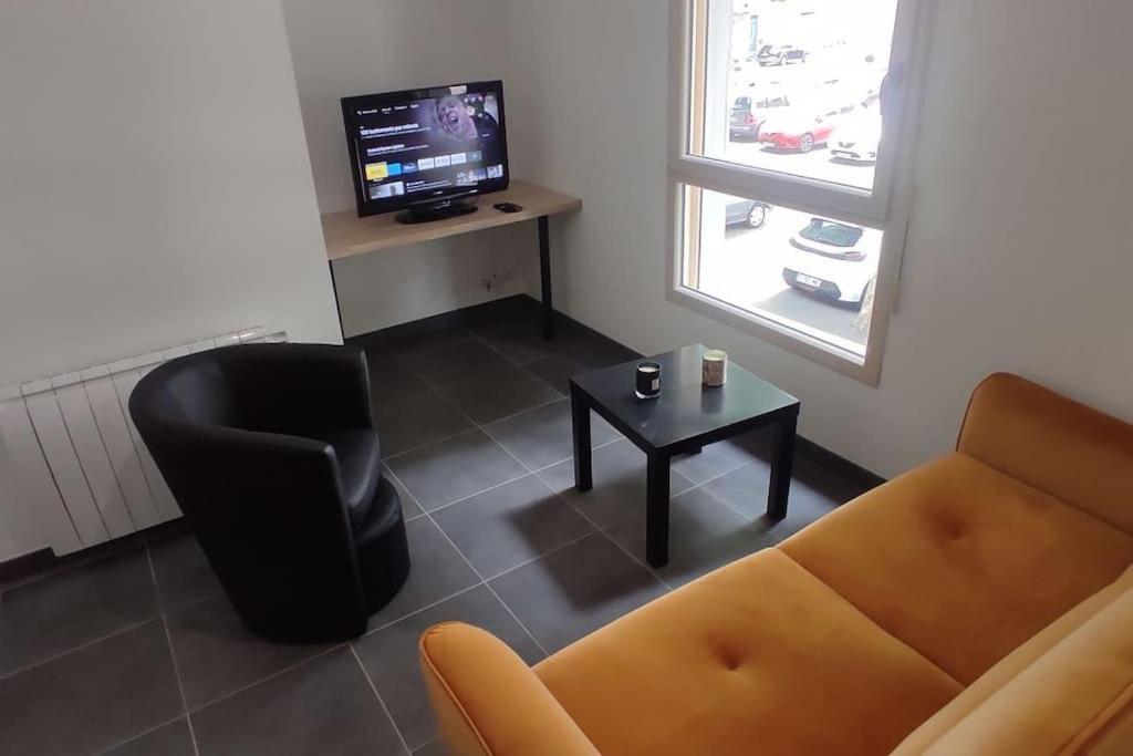 - un salon avec un canapé, une table et une télévision dans l'établissement Appartement hyper centre Mayenne, à Mayenne