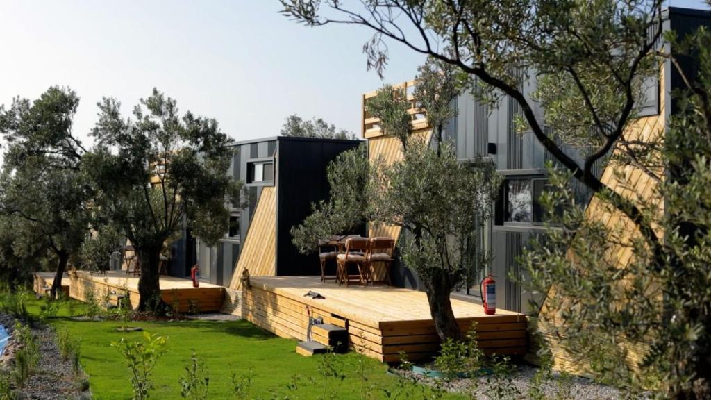 una casa con terraza de madera en un patio en ELIES TINY GLAMPING en Ayvalık