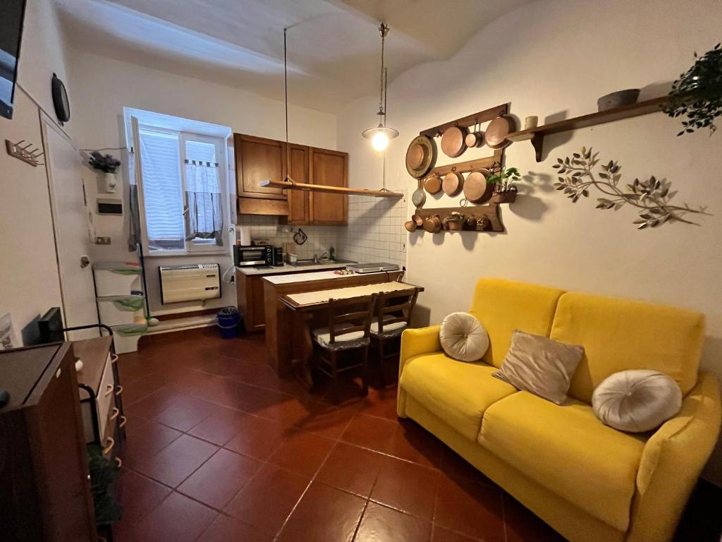 sala de estar con sofá amarillo y cocina en Alloggio ad uso turistico Piave 47- Charlotte's Houses, en Gradoli