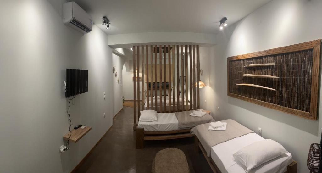 een kleine kamer met 2 bedden en een televisie bij Elia’s Guest House in Paralia Saranti