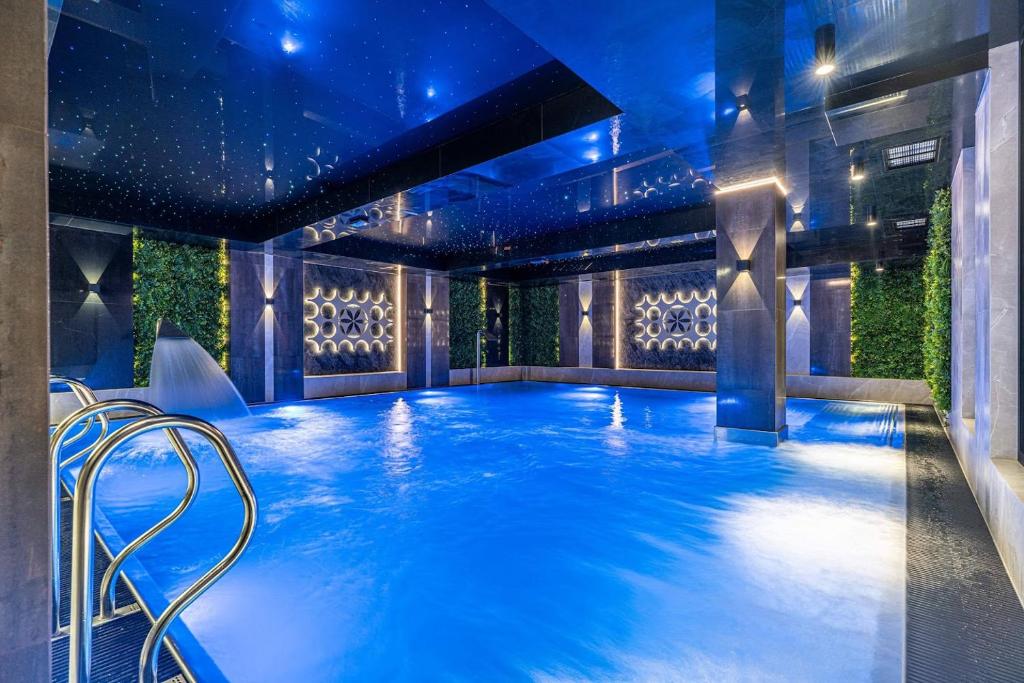 una piscina con illuminazione blu in un edificio di Góralski Resort Pool & SPA a Białka