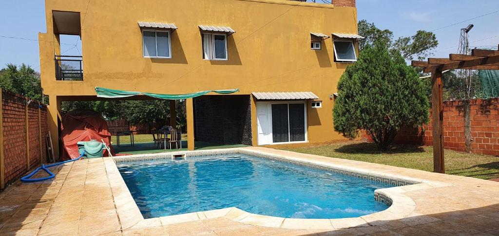 - une piscine en face d'une maison dans l'établissement Departamentos Serena, à Puerto Iguazú