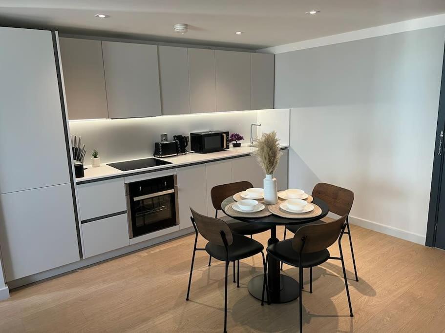 a kitchen with a table and chairs in a room at 2bedroom luxury apartment city centre in Manchester