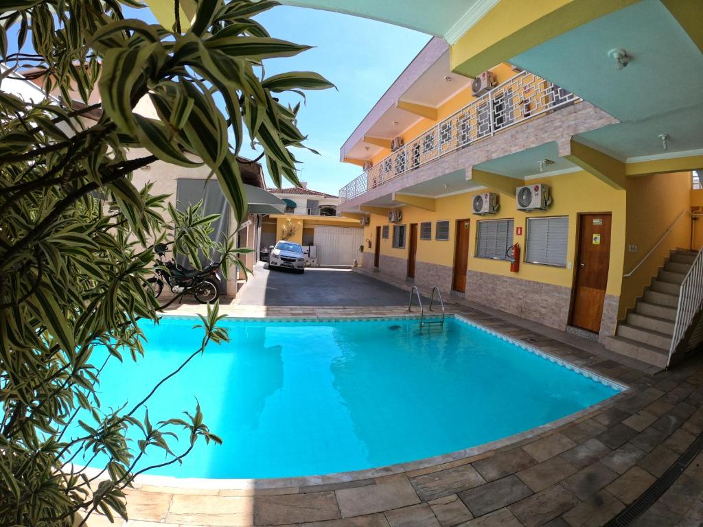 uma piscina numa villa com uma casa em Hotel Pousada Recanto da Madá em Aparecida