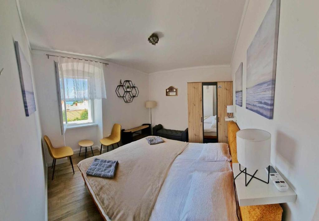 a bedroom with a large bed and a living room at Holiday Place Veli Dvor - vacation house with private garden in old town Punat in Punat