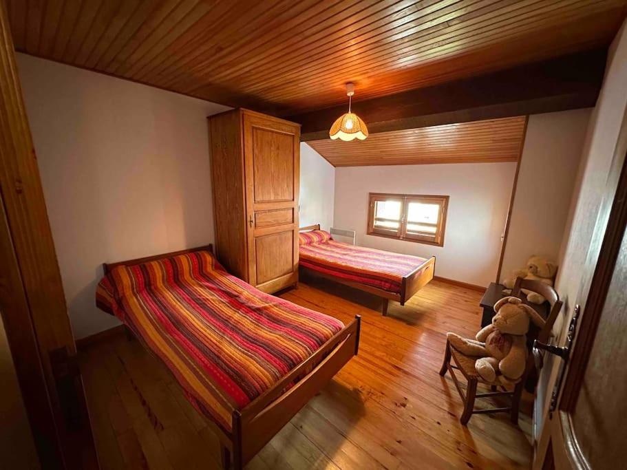 a bedroom with two beds and a chair in it at Maison familiale in Saint-Pierre-dels-Forcats