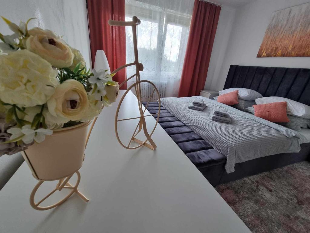 a living room with a table with a vase of flowers at Prostorný byt v centru u řeky, 2 ložnice, balkón in Hradec Králové