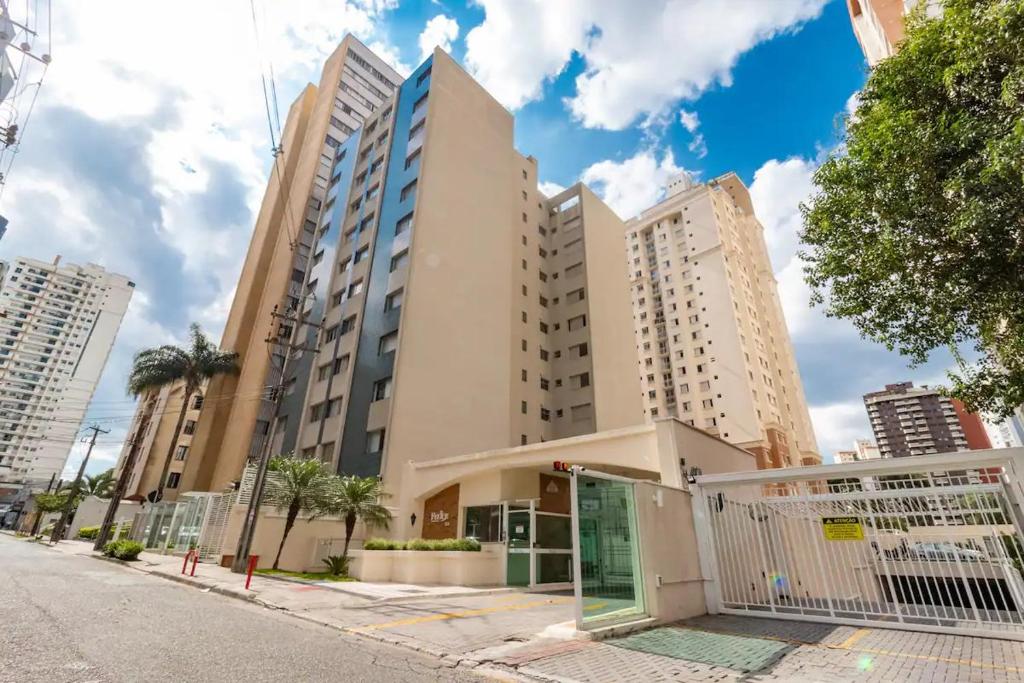 a building on a street with tall buildings at Condominio Felice Club in Curitiba