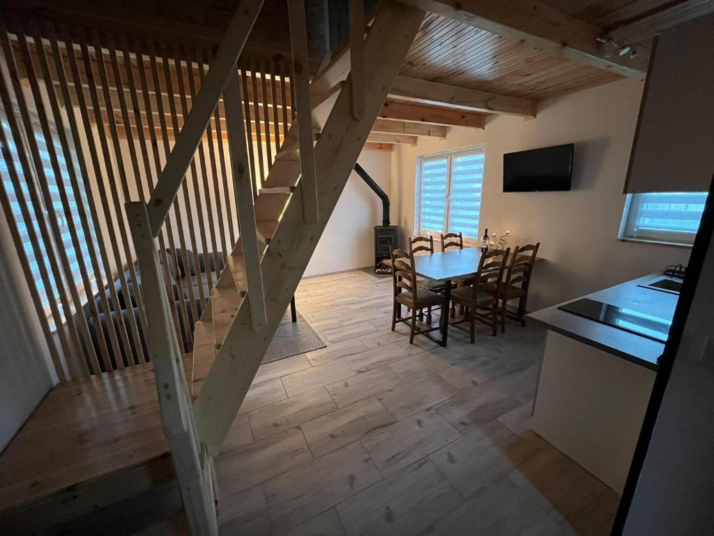 a kitchen and dining room with a wooden staircase in a house at Domki całoroczne STAWIK in Wodnica
