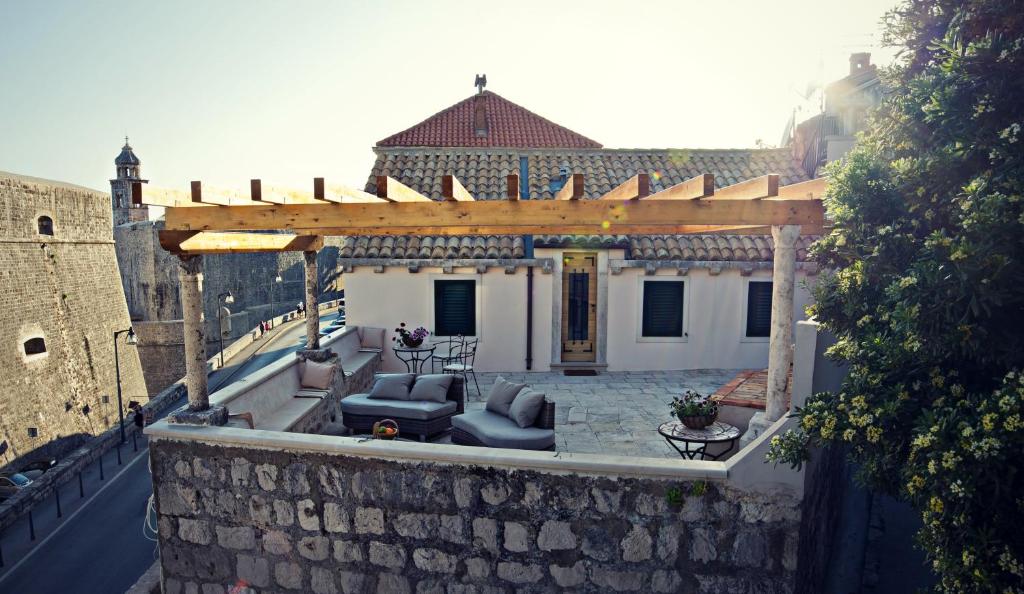 an outdoor patio with a wooden pergola on a building at Villa Ragusa Vecchia in Dubrovnik