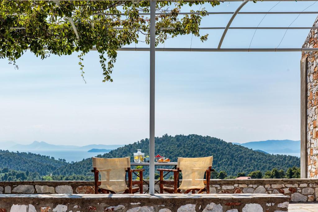una mesa y sillas frente a una gran ventana en ALTHEA, en Panormos Skopelos