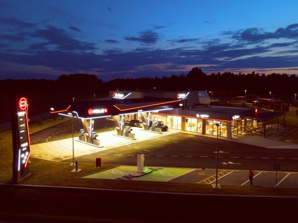 a gas station with a plane parked in a parking lot at Motel Prajo’s in Lukač