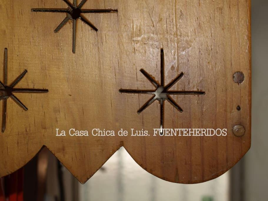 een houten klok met drie sterren erop bij La Casa Chica de Luis in Fuenteheridos
