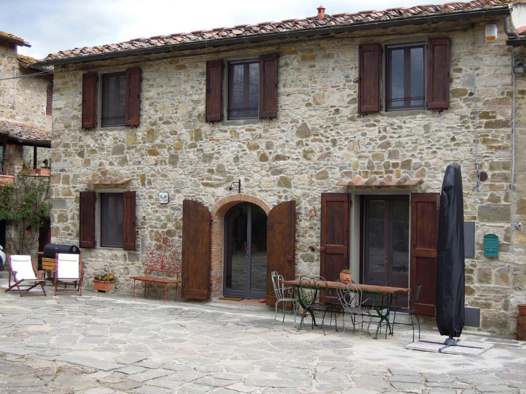 ein Steinhaus mit einem Tisch und Stühlen davor in der Unterkunft La Turra - Casa di Campagna in Greve in Chianti