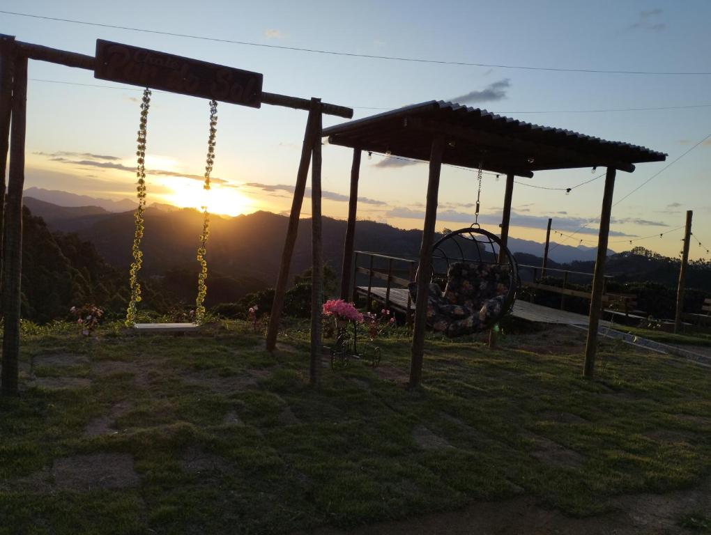 eine Schaukel mit Sonnenuntergang im Hintergrund in der Unterkunft Chalés Pôr Do Sol in Caparaó Velho