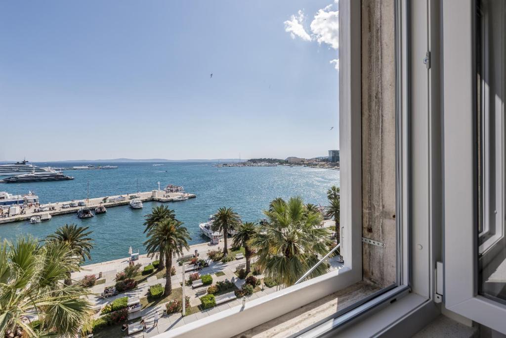 a window with a view of the water and a harbor at Palazzo Romano Suite 2 in Split