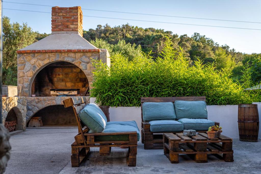 a patio with two chairs and a brick oven at Rezidencija Galileja in Mundanije