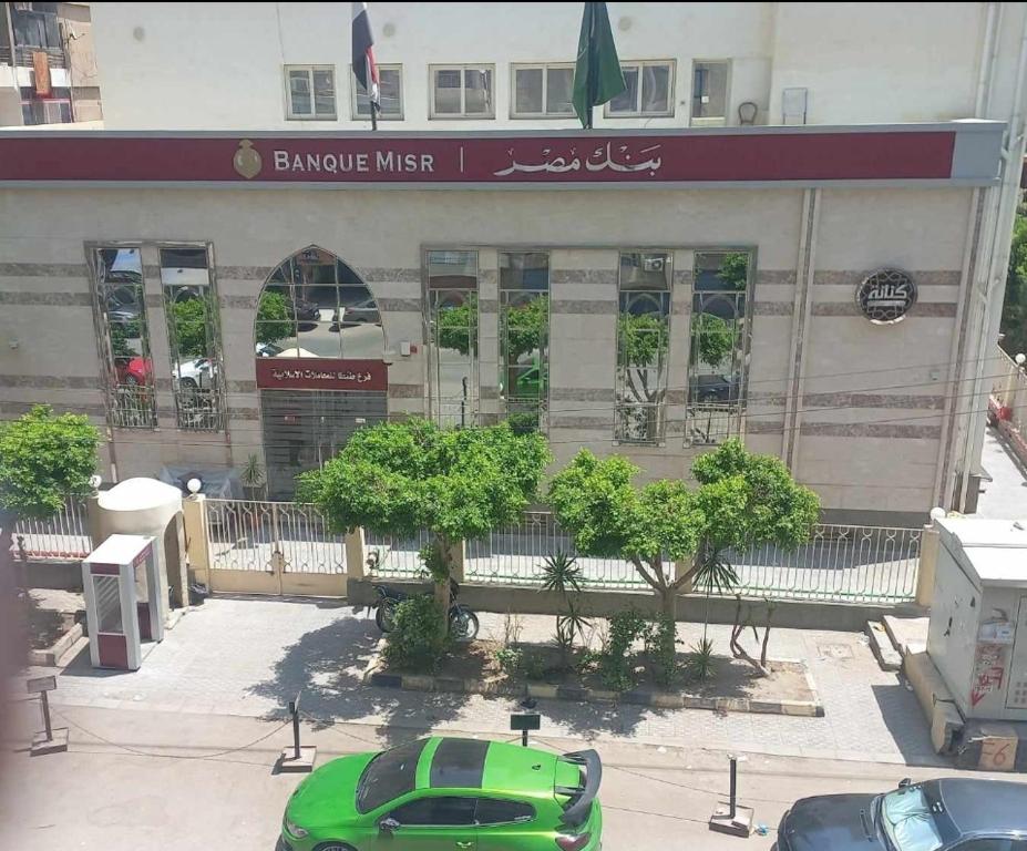 un'auto verde parcheggiata di fronte a un edificio di Tanta طنطا Families Only a Tanta