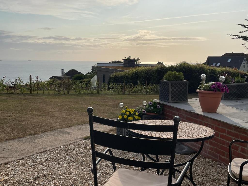 a table and a chair on a patio with the ocean at The Stoep in Paignton